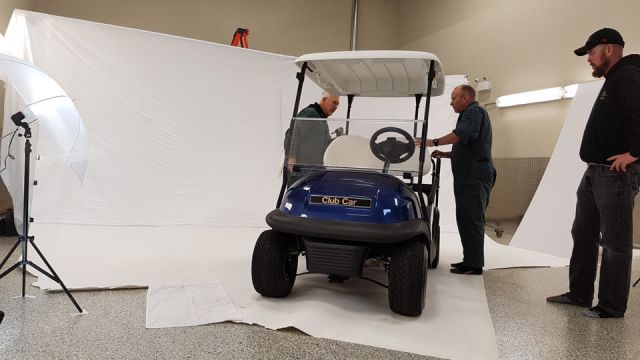 Men installing seats on to used Club Car golf cart for photo shoot
