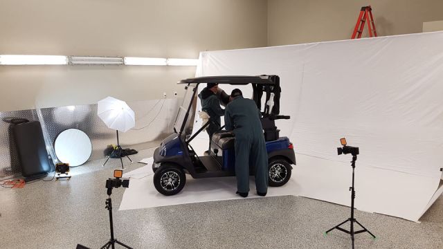 Men installing seats on to used Club Car golf cart for photo shoot